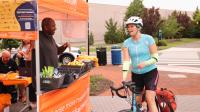 Cyclists enjoys free snacks offered by volunteer at Bike to Work Day 2024.